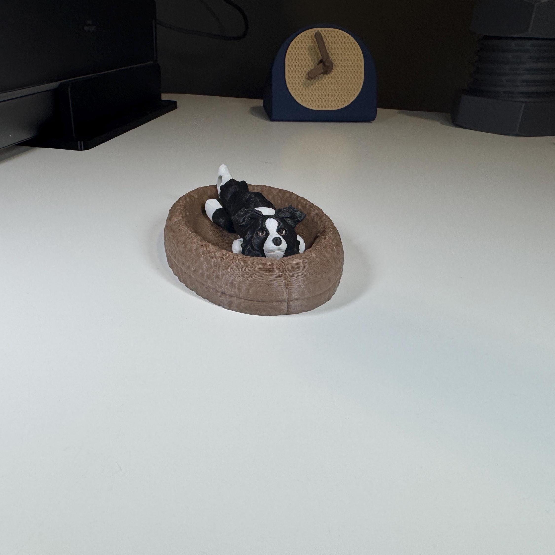 Border Collie Keychain laying in small pet bed.